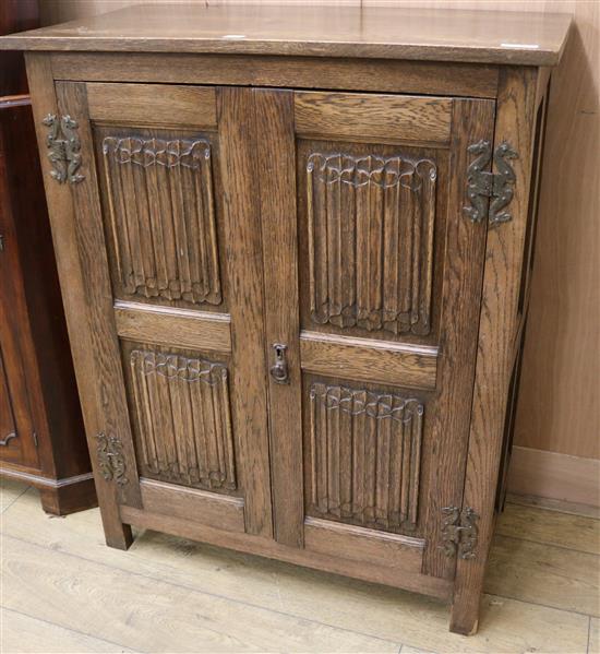 An oak linen fold cupboard W.92cm